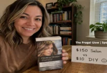 A happy woman with light brown hair and subtle honey highlights smiles while holding a $10 drugstore highlighting kit. Next to her, a handwritten sign shows "$150 vs $10" with a smiley face drawn next to the $10.