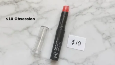 e.l.f. Glow Reviver Slipstick in shade Coral Kiss. The slim twist-up tube with clear cap is shown on a clean white surface. The product is partially twisted up to show the squishy gel texture. A small handwritten tag says "$10". Soft natural lighting.