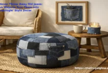 A beautiful, cozy living room corner with a rattan chair and a chunky knit throw blanket. On the floor sits a gorgeous denim patchwork ottoman made from different shades of blue jeans. On the wall hangs a framed denim pocket organizer with small dried flowers peeking out. A coffee mug sits on a denim coaster next to a candle in a denim-wrapped holder. The vibe is warm, boho, and shockingly professional.