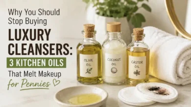 Glass bottles of olive oil, coconut oil, and castor oil next to a cotton pad removing makeup, on a marble bathroom counter | the frugal glow