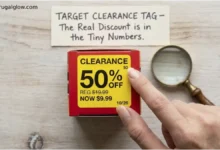 A Target clearance tag with a yellow sticker showing 50% off. A hand is pointing to the tiny number in the upper-right corner and the date stamp. A sign says "The Real Discount is in the Details."