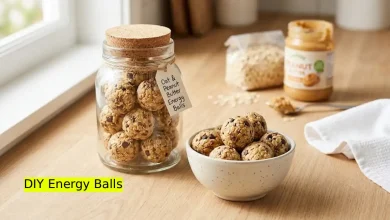 A glass jar and bowl filled with homemade oat and peanut butter energy balls on a kitchen counter.