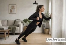 Person performing a doorframe row exercise using a standard white doorframe at home, with a towel wrapped around the frame for grip – no-equipment upper body workout for back and shoulders.