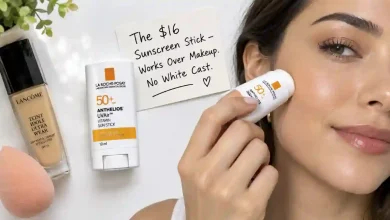 The La Roche-Posay Anthelios UVAir Vitamin Sun Stick SPF50+ in its compact 10ml tube. Next to it, a hand applying the stick over a full face of makeup. A sign says "$16 – Works Over Makeup, No White Cast."