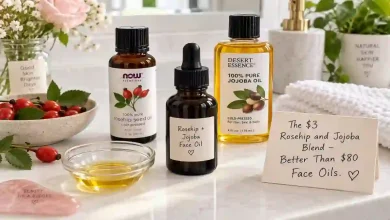 A small dark glass dropper bottle filled with homemade rosehip and jojoba face oil. Next to it, a bottle of rosehip seed oil, a bottle of jojoba oil, and a small bowl. A sign says "$3 vs $80 – Same Glow."